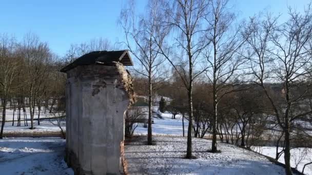 Vlucht in het winterpark. Vlieg over de ruïnes van het oude gebouw. De drone vliegt rond de ruïnes.. — Stockvideo