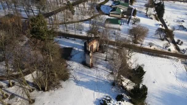 Voo sobre o parque de inverno. Abaixo estão as ruínas de um edifício antigo. O drone aproxima-se das ruínas. — Vídeo de Stock