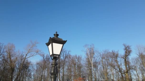 Voe sobre uma lanterna vintage. O drone voa ao redor da lanterna contra o céu azul. — Vídeo de Stock