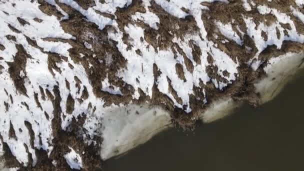 Vuelo sobre el río Svisloch en Loshitsky Park, Minsk. Hay nieve en la orilla del río. Los edificios de la ciudad son visibles en la distancia — Vídeos de Stock