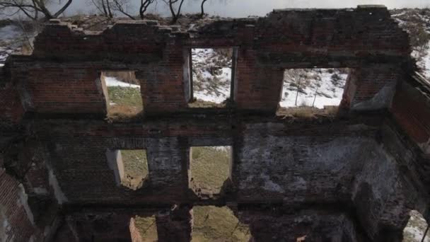 Ruinerna av en gammal kvarn i Loshitsa Park, Minsk, Vitryssland. Kameran flyger över lådan i en gammal förstörd byggnad. Vinterlandskap. — Stockvideo