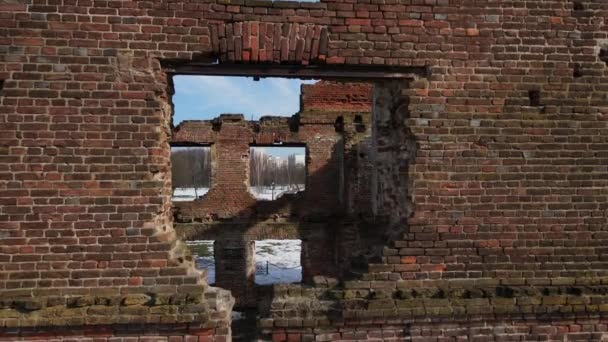 Ruinas de un antiguo molino en Loshitsa Park, Minsk, Bielorrusia. Volando a través de la ventana que se abre en las paredes y despegando en altura. Paisaje invierno. — Vídeos de Stock