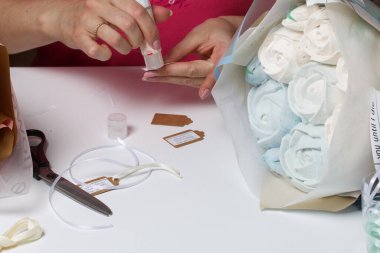 Bir kadın ambalaj kağıdında zephyr buketleri paketliyor. Zephyr 'den laleler ve güller.