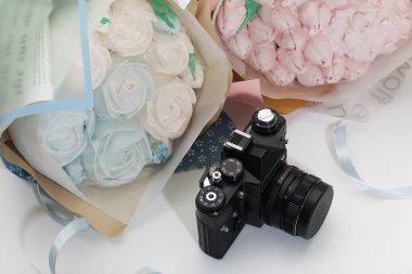 Ambalaj kağıdında Zephyr buketi. Zephyr 'den laleler ve güller. Yakınlarda antika bir kamera var..