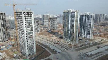 Geniş bir yerleşim alanı inşaatı. İnşaat alanı görünür durumda. Çok katlı binalar ve altyapı yapım aşamasında. İnşaatın hava fotoğrafçılığı.