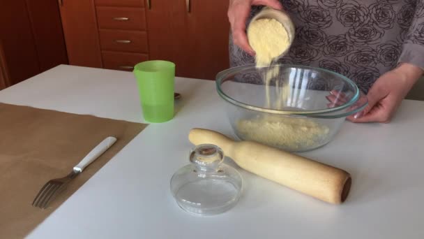 Egy nő kenyeret csinál kukoricalisztből. Keveri a lisztet és a vizet. kovásztalan kenyeret készít.. — Stock videók