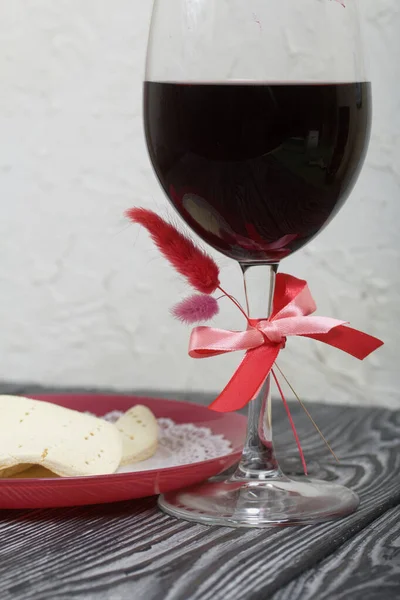 A glass of dry red wine and unleavened bread on a plate. Celebration of the Lord\'s Supper.