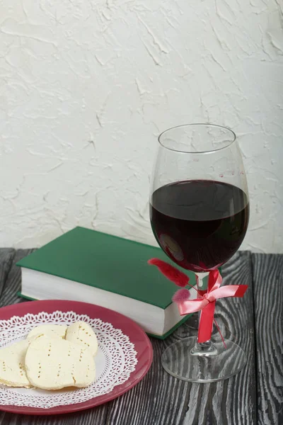 A glass of dry red wine and broken unleavened bread lie on a plate. To celebrate the Lord\'s Supper. Nearby lies the Bible.