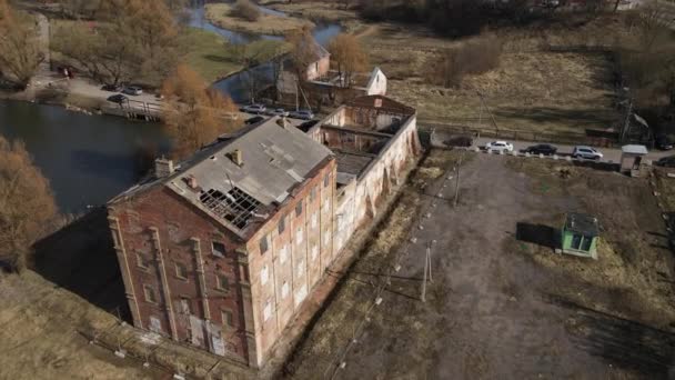 Distillery in Loshitsa Park. Fly forward over ruined old buildings. The collapsed roof and crumbling brick are visible. Lifeless spring landscape. — Stock Video