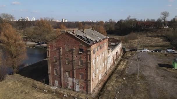 Brennerei im Loshitsa Park. Fliegen Sie über die zerstörten alten Gebäude. Das eingestürzte Dach und der bröckelnde Ziegel sind zu sehen. Lebenslose Frühlingslandschaft. — Stockvideo