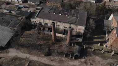 Terk edilmiş sanayi bölgesi. Eski tuğla binalar ve fabrika bacaları. Yeni bir şehir bloğunun etrafında. Hava fotoğrafçılığı