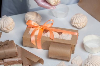 Bir kadın ev yapımı marşmelov paketliyor. Evde zephyr pişiriyorum..