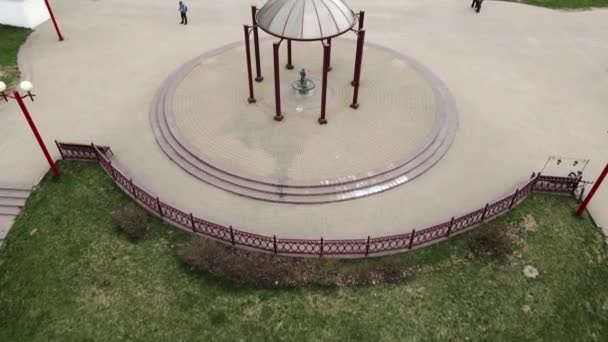 Flucht im frühlingshaften Stadtpark. Über dem Pavillon mit Trinkbrunnen. — Stockvideo