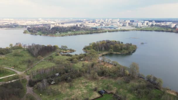 Volo nel parco cittadino di primavera. verso il serbatoio. L'isolato della città è visibile in lontananza. — Video Stock