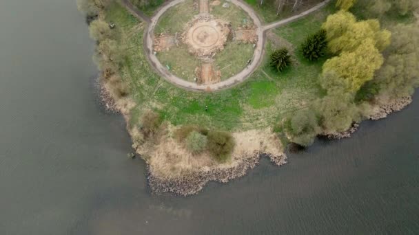 Flight near the reservoir in the city park. Destroyed footpaths are visible. — Stock Video