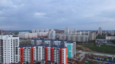 İnsansız hava aracı yeni şehir bloğuna doğru uçuyor. Çok katlı binalar, şantiye görünür durumda..