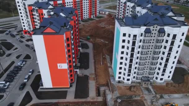 Беспилотник пролетает над новым кварталом. Многоэтажные здания, видна строительная площадка. — стоковое видео
