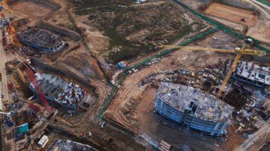 Büyük bir inşaat alanı. Çok katlı binaların inşaatı başladı. Kule vincleri ayakta. İnşaatın hava fotoğrafçılığı.