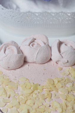 Şekerli kek. Bisküvi, lokum ve jöle katmanları. Marşmelov gülleri ve badem yapraklarıyla süslenmiş..