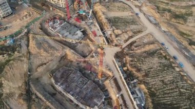 Büyük bir inşaat alanı. İnşaat halindeki binalar görülebilir. Kule vincleri ayakta. İnşaatın hava fotoğrafçılığı.