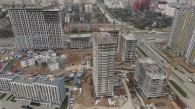 Büyük bir inşaat alanı. Şehir merkezinde inşaat halindeki çok katlı binalar. Hava video çekimi.