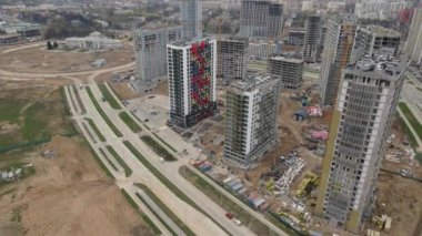 İnşaat alanından uçarak geldim. Şehir merkezinde inşaat halindeki çok katlı binalar. Çok işlevli şehir inşaatı. Hava video çekimi.