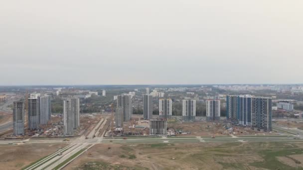 Velké staveniště. Vícepodlažní budovy ve výstavbě v městské čtvrti. Let ke stavbě. Natáčení leteckého videa. — Stock video