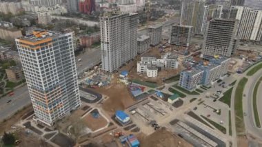 İnşaat alanının üzerinden uçuş. İnşaat halindeki yüksek binalar ve inşaat vinçleri görülebiliyor. Hava fotoğrafçılığı.