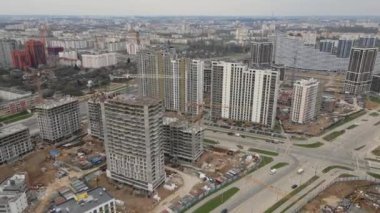İnşaat alanının üzerinden uçuş. Kamerayı çevirerek. İnşaat halindeki yüksek binalar ve inşaat vinçleri görülebiliyor. Hava fotoğrafçılığı.