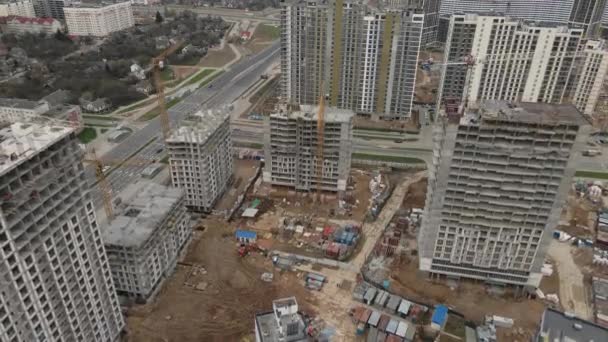 Let nad staveništěm. Výškové budovy ve výstavbě a stavebních jeřábech jsou viditelné. Letecká fotografie.. — Stock video