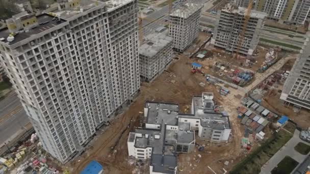 Vlucht over de bouwplaats. Met een draai van de camera. Hoge gebouwen in aanbouw en bouwkranen zijn zichtbaar. Luchtfotografie — Stockvideo