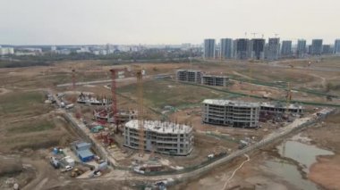 İnşaat alanının üzerinden uçuş. Çok katlı binaların yapımı. Modern şehir gelişimi. Hava videosu.