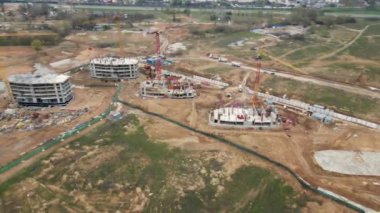 İnşaat alanının üzerinden uçuş. İlk aşamada inşaat halindeki evler görülebilir durumda. Kamerayı çevirerek uçmak. Aerofideografi.