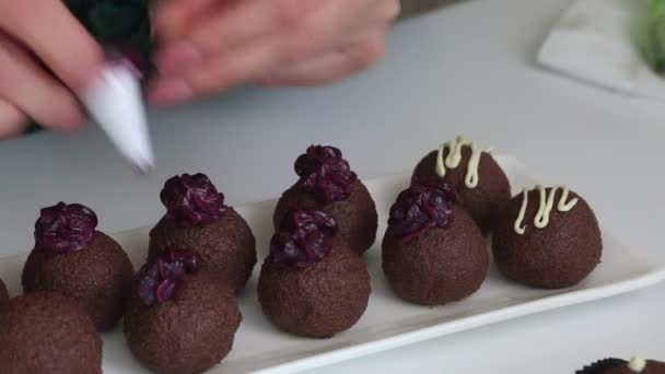 A mulher faz um brownie de batata. Os bolos estão na mesa. Uma mulher decora doces com creme de um saco de pastelaria. Imagem de close-up. — Vídeo de Stock