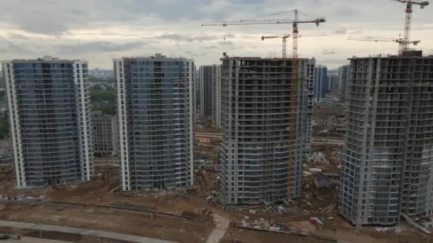 Modern urban development. Construction site with multi-storey buildings under construction.  Construction work is underway. Departure from houses. Aerial videography. — Stock Video