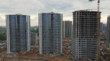 İnşaat alanında çok katlı binalar inşa ediliyor. Modern şehir gelişimi. İnşaat çalışmaları devam ediyor. Geri uç. Hava videosu.