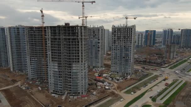 Desarrollo urbano moderno. Sitio de construcción con edificios de varios pisos en construcción. Los trabajos de construcción están en marcha. Videografía aérea. — Vídeos de Stock