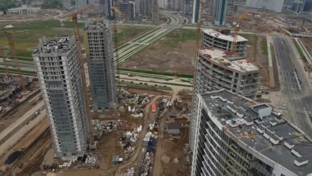 Construction site with multi-storey buildings under construction. Modern urban development. Construction work is underway.  Aerial videography. — Stock Video