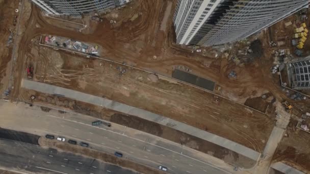 Construction site with multi-storey buildings under construction. Modern urban development. Construction work is underway. The camera is down. Aerial videography. — Stock Video