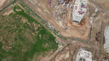 İnşaat alanında çok katlı binalar inşa ediliyor. İnşaat çalışmaları devam ediyor. Modern şehir gelişimi. Hava videosu.