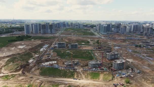 Stavba s vícepodlažními budovami ve výstavbě. Stavební práce jsou v plném proudu. Moderní rozvoj měst. Zastřelen širokým záběrem. Letecká videografie. — Stock video