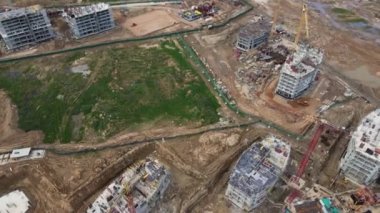 İnşaat alanında çok katlı binalar inşa ediliyor. Modern şehir gelişimi. İnşaat çalışmaları devam ediyor. Kamerayı çevirerek uçmak. Hava videosu.