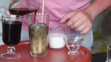 Blue Ice Latte yapıyorum. Bardaktaki erkek malzemeleri. Yakınlarda bir tarif aradığı bir dizüstü bilgisayar var. Yakın çekim..
