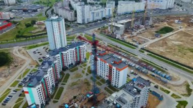 Yeni kentsel gelişimin havadan görüntüsü. Yeni evler inşa ediliyor. İnşaat halindeki bir bloğun etrafında daire çizin. Turnalar görünür..