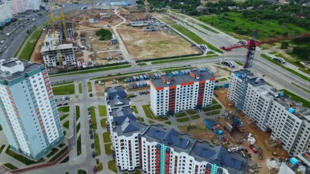 Luchtfoto van de nieuwe stedelijke ontwikkeling. Er worden nieuwe huizen gebouwd. Vlucht in een cirkel rond het blok in aanbouw. De kranen zijn zichtbaar — Stockvideo