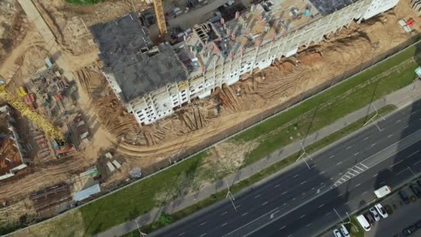 Veduta aerea del nuovo sviluppo urbano. Stanno costruendo nuove case. C'è una gru a torre nel centro dell'edificio. Fai volare giù la telecamera. — Video Stock