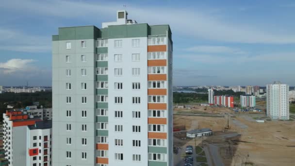 Fotografía aérea de la obra. Construcción de modernos edificios de varios pisos. Estamos volando desde detrás de la casa. Una vista de la obra y la grúa se abre. — Vídeos de Stock