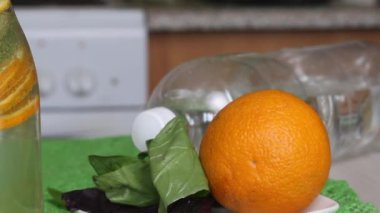 Portakal ve fesleğenle doldurulmuş şişe suyu. Detoks su tarifleri