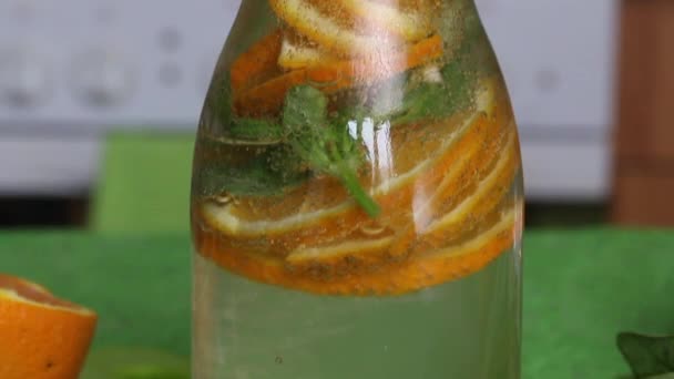 Gebotteld water doordrenkt met sinaasappel en basilicum. Detox water recepten.. — Stockvideo