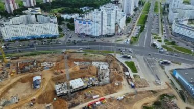 İnşaat alanının hava fotoğrafları. Modern bir şehir bloğunun inşaatı başlıyor. İnşaat vinçleri şantiyede. Daire içinde uçmak _